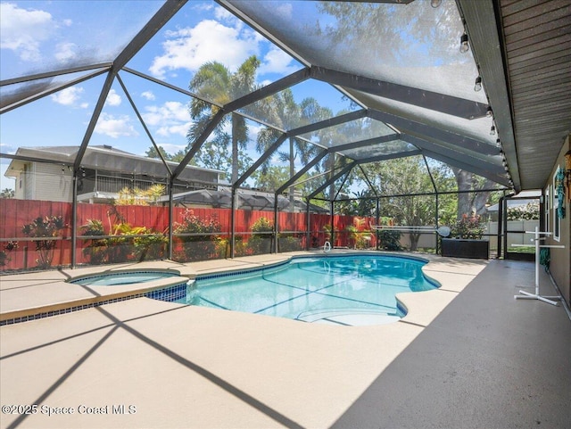 view of pool featuring a fenced backyard, a patio, a pool with connected hot tub, and a lanai