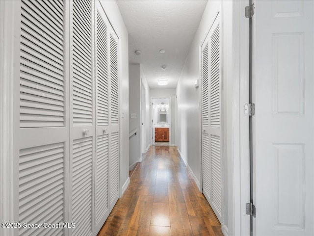 hallway featuring baseboards and hardwood / wood-style floors