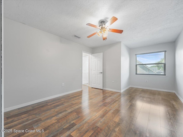 unfurnished bedroom featuring a textured ceiling, a ceiling fan, baseboards, wood finished floors, and visible vents