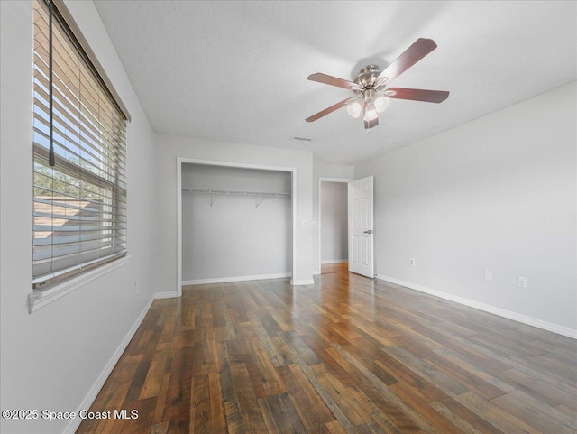 unfurnished bedroom with a ceiling fan, baseboards, wood finished floors, visible vents, and a closet