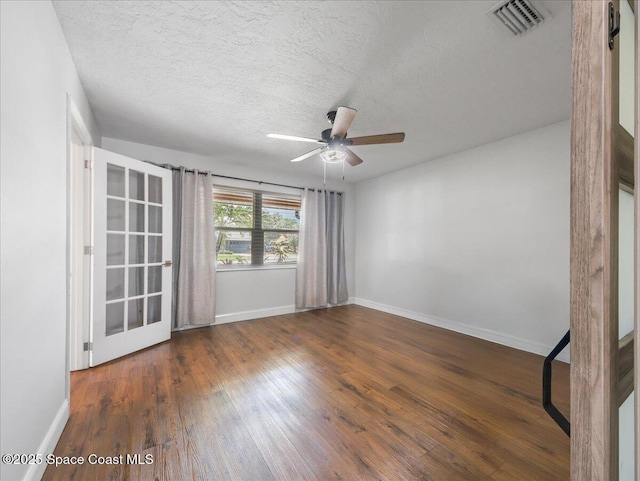 unfurnished room with a ceiling fan, baseboards, visible vents, and wood finished floors