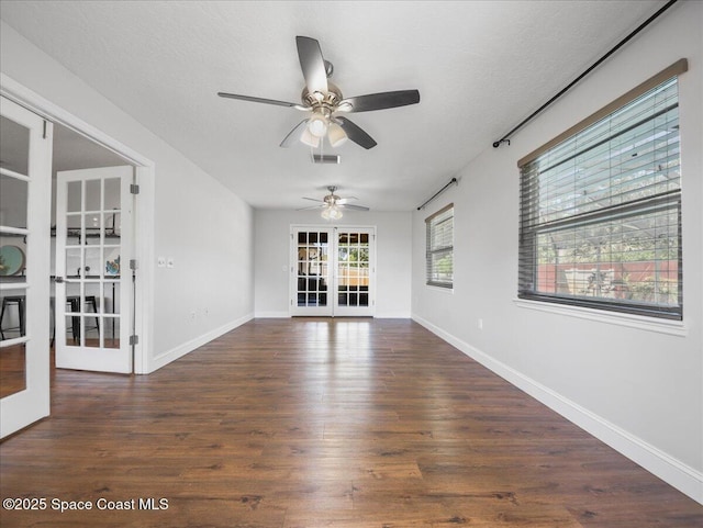 spare room with a ceiling fan, french doors, wood finished floors, and visible vents