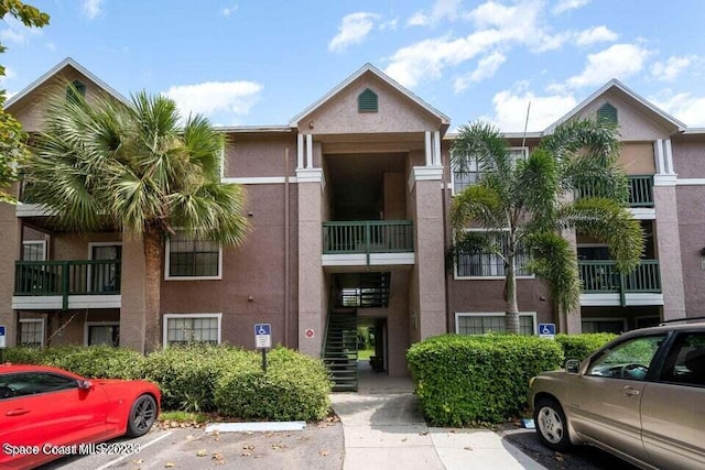 7667 N Wickham Rd Unit 903, Melbourne, FL 32940 - view of property with uncovered parking and stairway