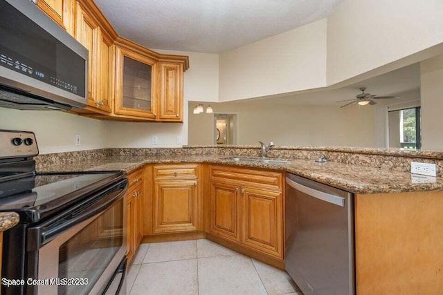 7667 N Wickham Rd Unit 903, Melbourne, FL 32940 - kitchen with appliances with stainless steel finishes, stone countertops, brown cabinets, and a peninsula