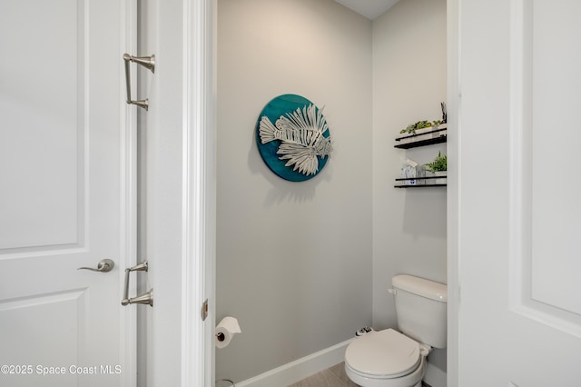 bathroom featuring baseboards and toilet