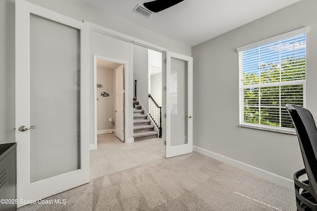 unfurnished office featuring carpet floors, baseboards, a wealth of natural light, and french doors