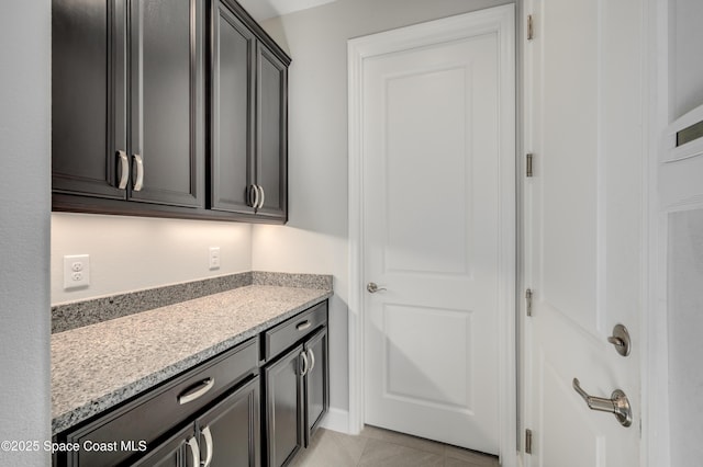 clothes washing area featuring light tile patterned floors