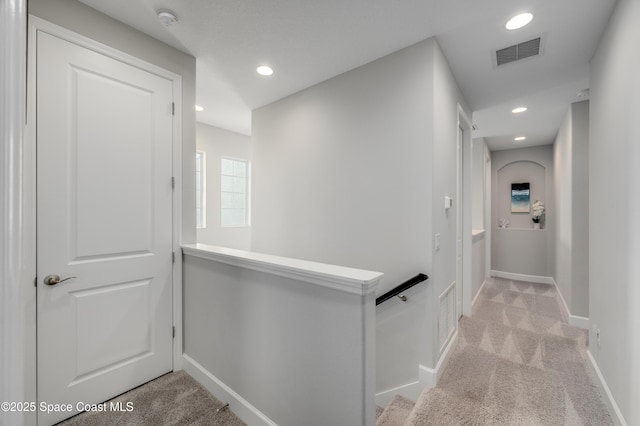 hallway with recessed lighting, visible vents, and light carpet