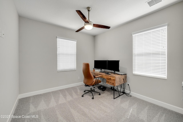 carpeted office space with baseboards, a ceiling fan, and visible vents