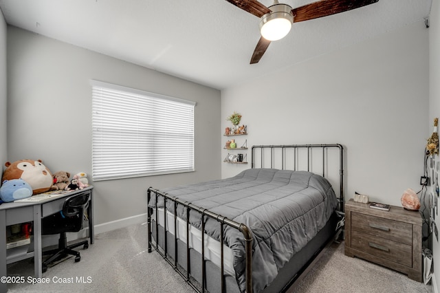 carpeted bedroom with a ceiling fan and baseboards