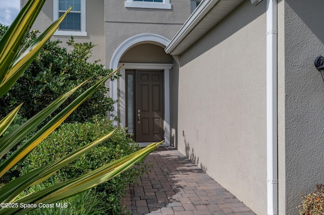 view of exterior entry featuring stucco siding