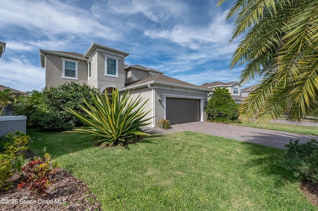 view of front of property featuring an attached garage, driveway, a front yard, and stucco siding