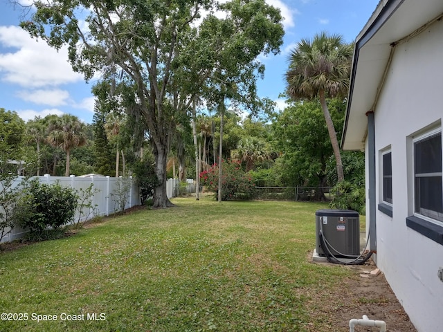 view of yard with a fenced backyard and central AC unit