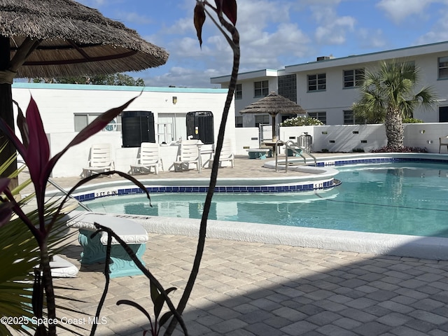 pool featuring fence and a patio