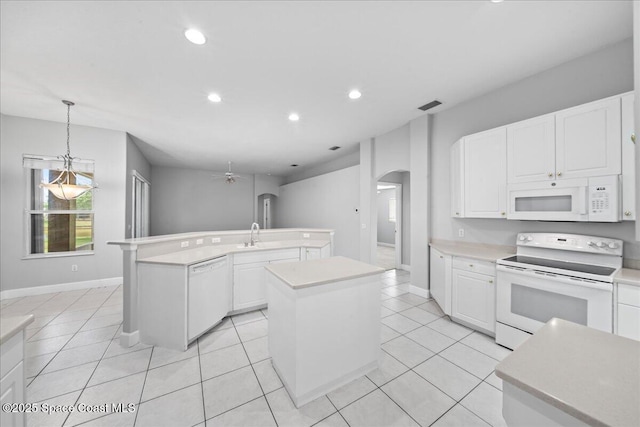 kitchen featuring visible vents, white appliances, an island with sink, ceiling fan, and arched walkways