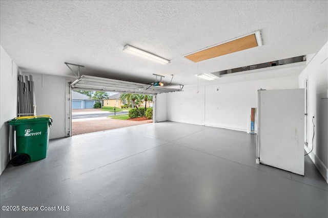 garage with freestanding refrigerator and a garage door opener