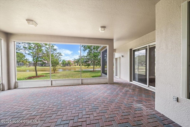 unfurnished sunroom with a water view and plenty of natural light