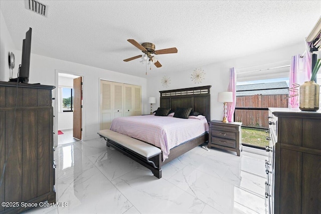 bedroom with visible vents, a textured ceiling, a closet, and multiple windows