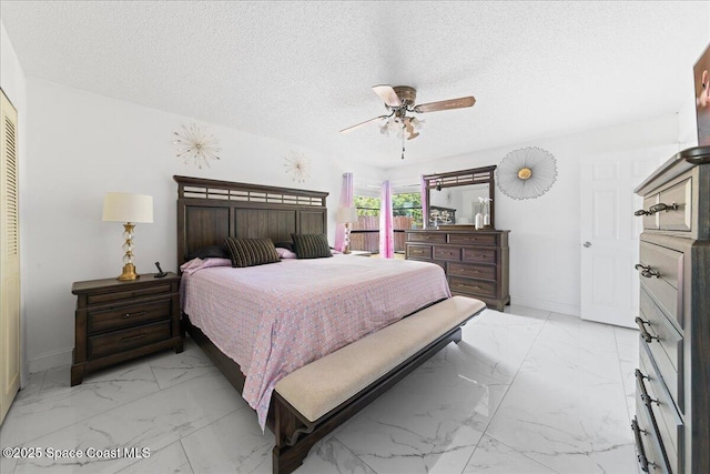 bedroom with a textured ceiling, baseboards, a ceiling fan, and marble finish floor
