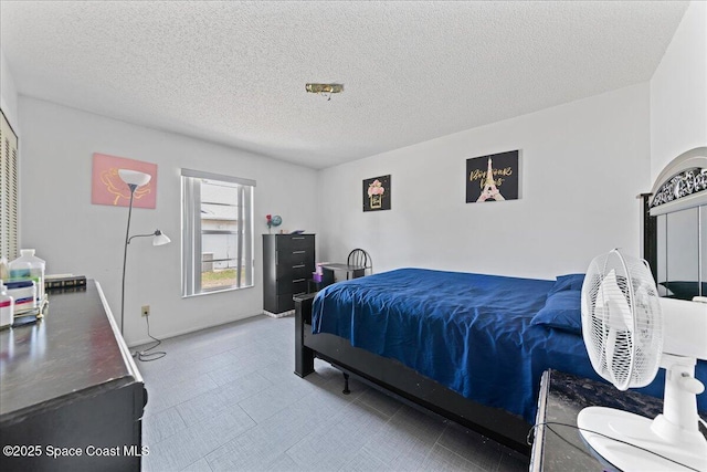 bedroom with baseboards and a textured ceiling
