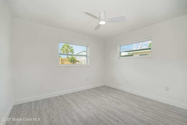 unfurnished room featuring baseboards, plenty of natural light, and light wood finished floors