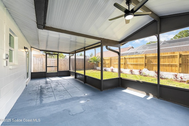 unfurnished sunroom with ceiling fan and beamed ceiling