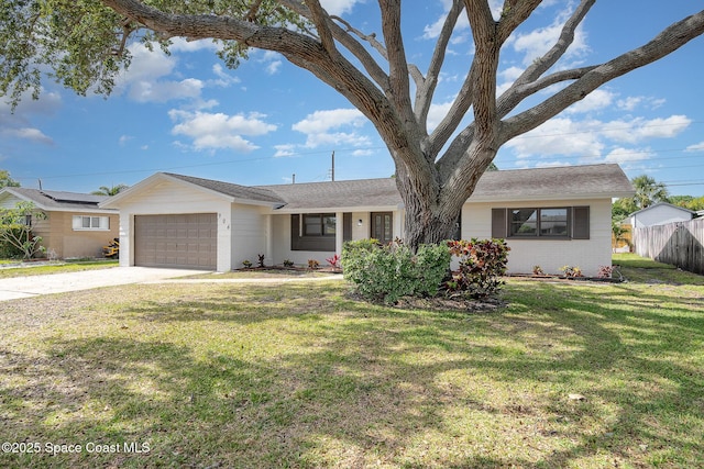 ranch-style house with fence, a front yard, brick siding, an attached garage, and driveway