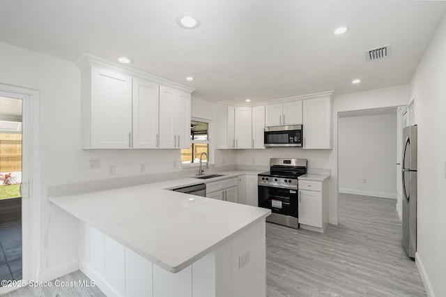 kitchen with visible vents, a sink, baseboards, and appliances with stainless steel finishes