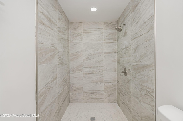 bathroom with toilet, recessed lighting, and tiled shower