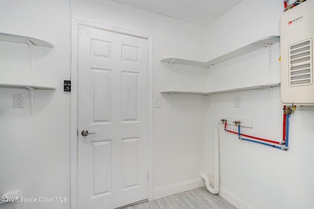 laundry room featuring baseboards, laundry area, light wood finished floors, and hookup for a washing machine