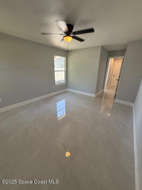 unfurnished room featuring baseboards and ceiling fan