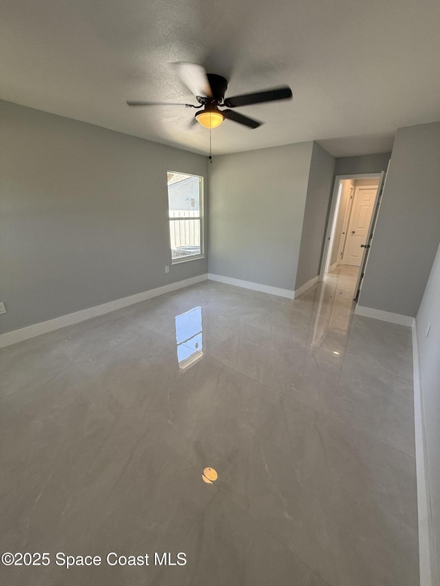 unfurnished room featuring light tile patterned flooring, ceiling fan, and baseboards