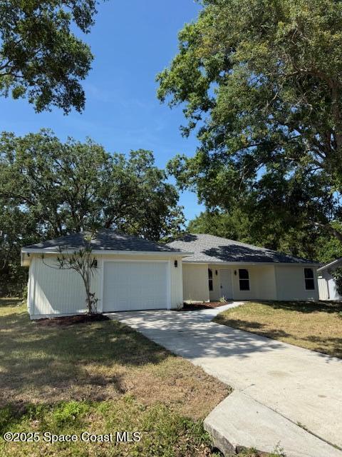 ranch-style house with a garage, driveway, and a front yard
