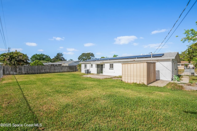 621 Plymouth St, Melbourne, FL 32935 - exterior space featuring a fenced backyard, stucco siding, a lawn, and solar panels