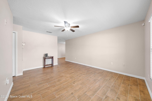 unfurnished living room with baseboards, ceiling fan, light wood-style flooring, and visible vents