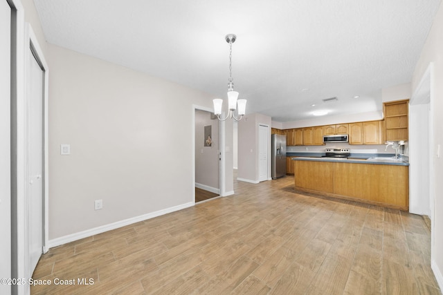 kitchen featuring open shelves, open floor plan, light wood-type flooring, a notable chandelier, and stainless steel appliances