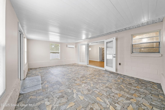 spare room featuring stone floors and a wall mounted AC