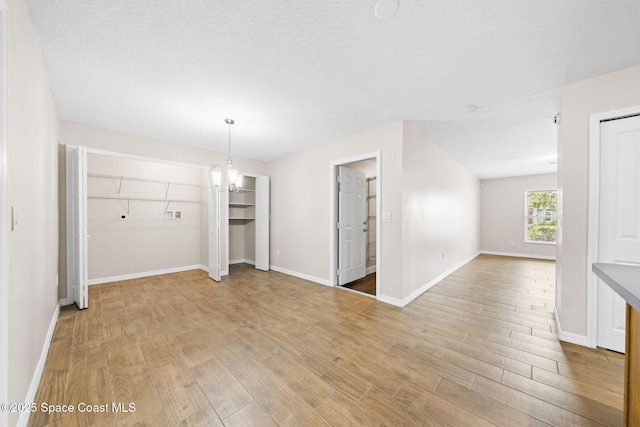 interior space with baseboards, an inviting chandelier, and light wood-style floors