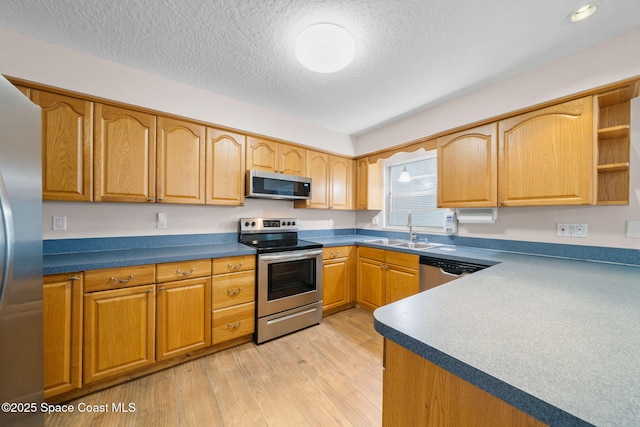 kitchen with open shelves, a textured ceiling, a sink, light wood finished floors, and appliances with stainless steel finishes