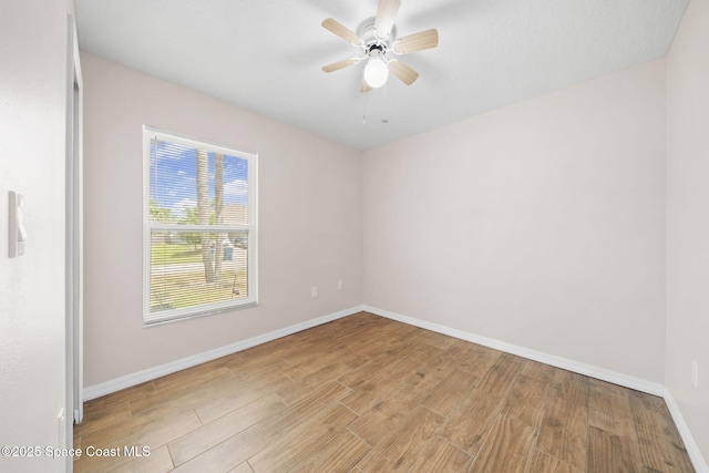 empty room with a ceiling fan, baseboards, and light wood-style flooring