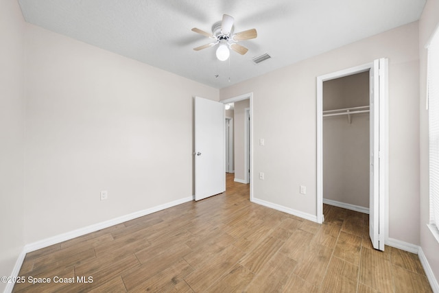 unfurnished bedroom featuring baseboards, visible vents, light wood-style flooring, and a closet