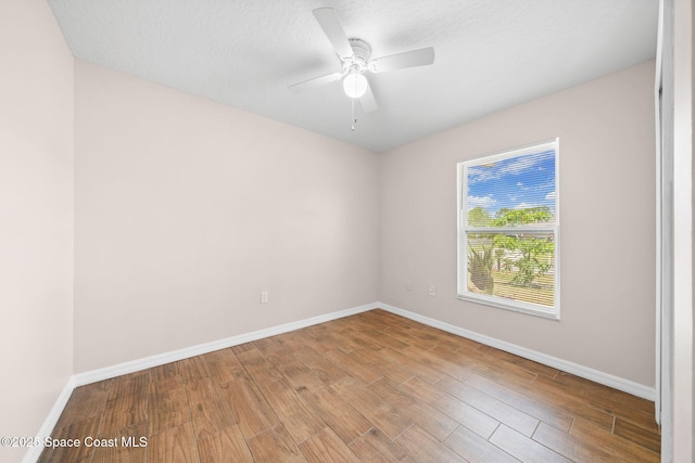 spare room with baseboards, a ceiling fan, and wood finished floors