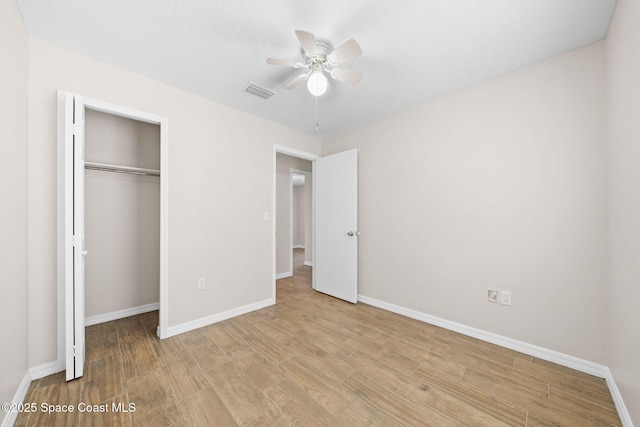 unfurnished bedroom featuring baseboards, visible vents, wood finished floors, and a closet