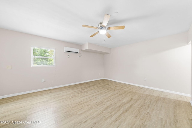 unfurnished room featuring light wood-type flooring, a wall mounted air conditioner, baseboards, and a ceiling fan