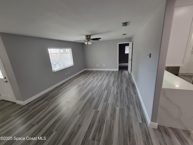 2175 Dumas St, Merritt Island, FL 32952 - unfurnished living room with a ceiling fan, wood finished floors, and baseboards