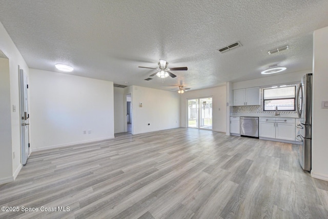 unfurnished living room featuring a ceiling fan, a textured ceiling, visible vents, and light wood-type flooring