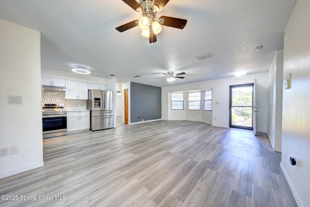 unfurnished living room featuring a ceiling fan, a textured ceiling, baseboards, and light wood finished floors