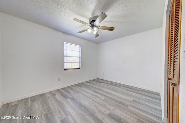 unfurnished bedroom featuring baseboards, ceiling fan, light wood-type flooring, and a textured ceiling