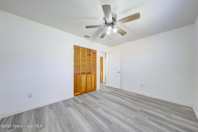 empty room featuring baseboards, visible vents, ceiling fan, and light wood finished floors