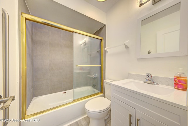 bathroom with vanity, enclosed tub / shower combo, toilet, and wood finished floors